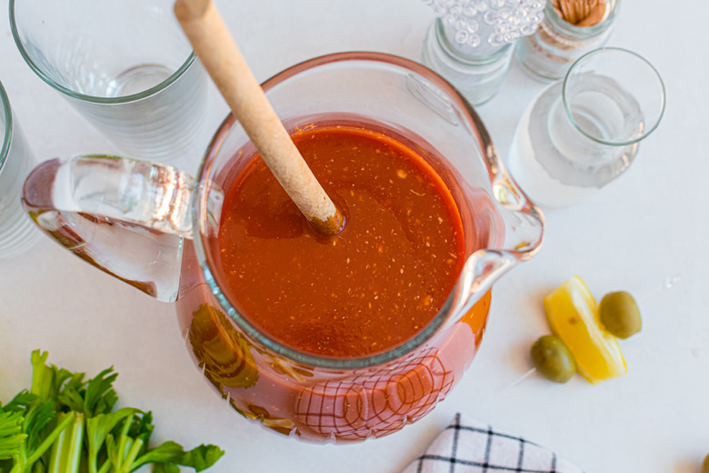 overhead of bloody mary mix in a glass pitcher 