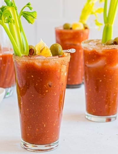 three glasses of bloody mary with garnish