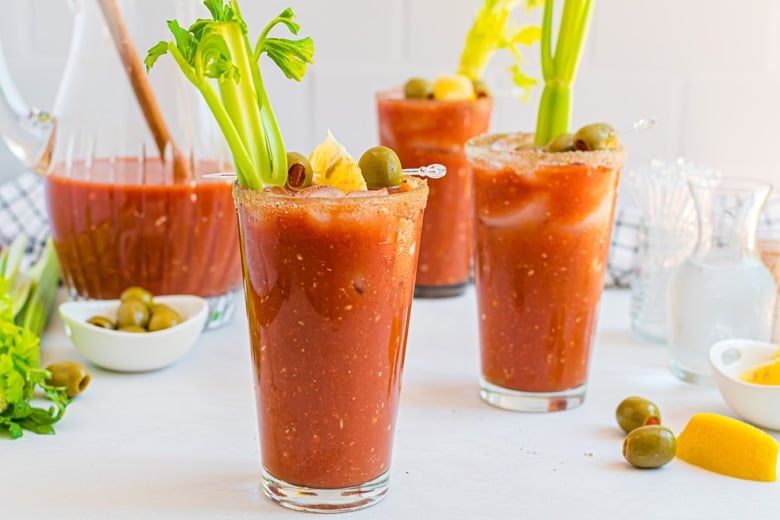three glasses of bloody mary with garnish
