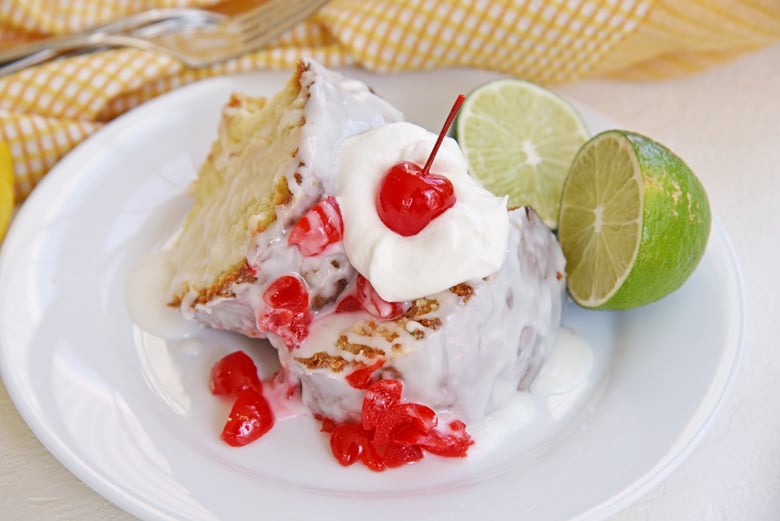 two slices of 7 up pound cake on a white plate with whipped cream and cherries  