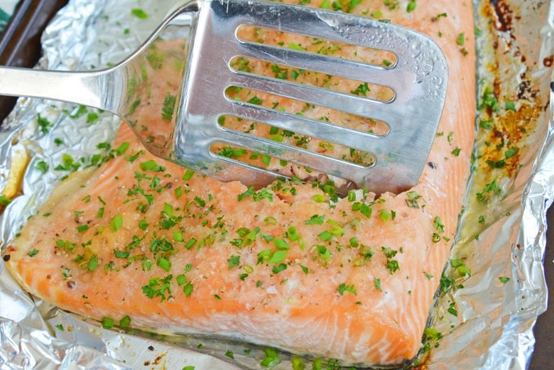 spatula cutting into baked salmon recipe