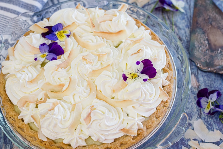 angle of coconut cream pie on blue table 