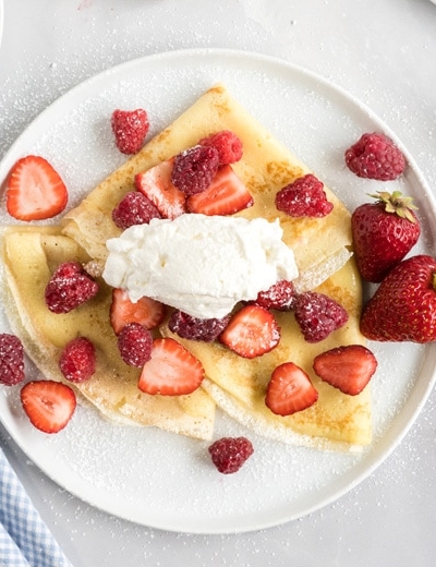 overhead of whipped cream and crepes