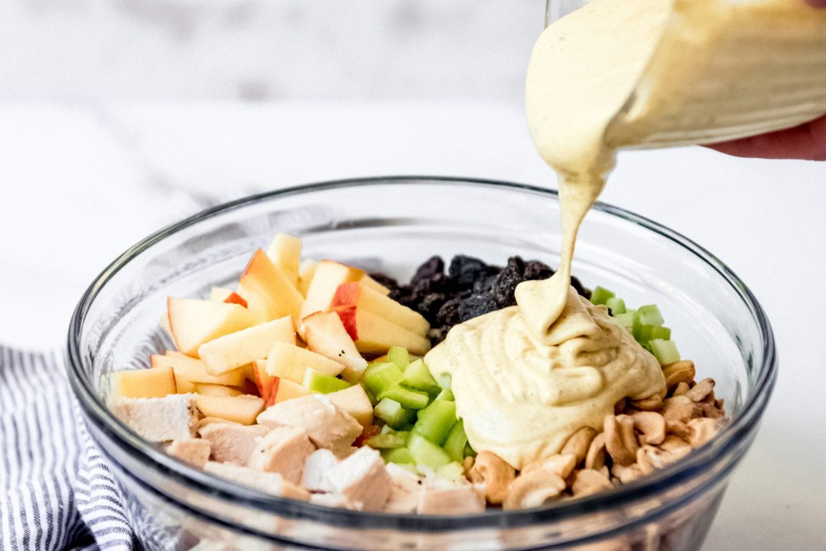 creamy dressing pouring on chicken salad 