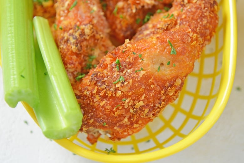 close up of crispy buffalo wing with celery 