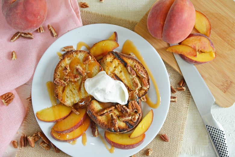 overhead of cake on a white plate with fresh peaches  