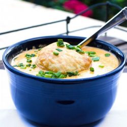 lobster bisque in a blue bowl topped with a biscuit