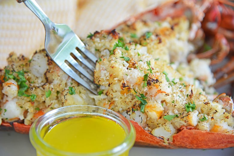 fork digging into a seafood stuffed lobster 