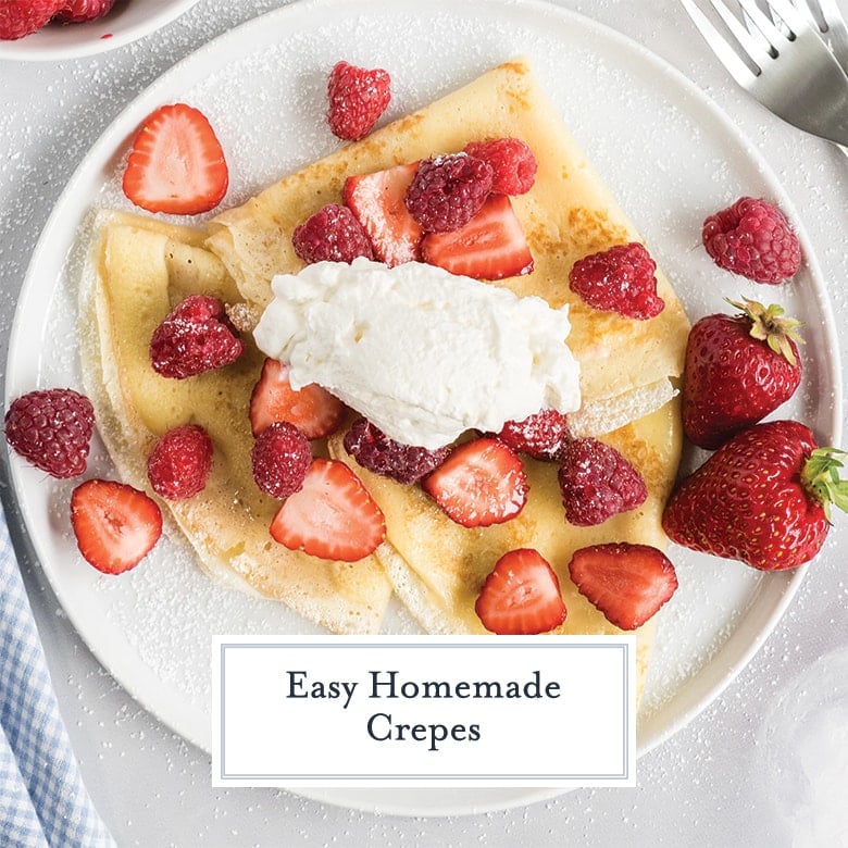overhead of crepes with fresh berries, whipped cream and powdered sugar
