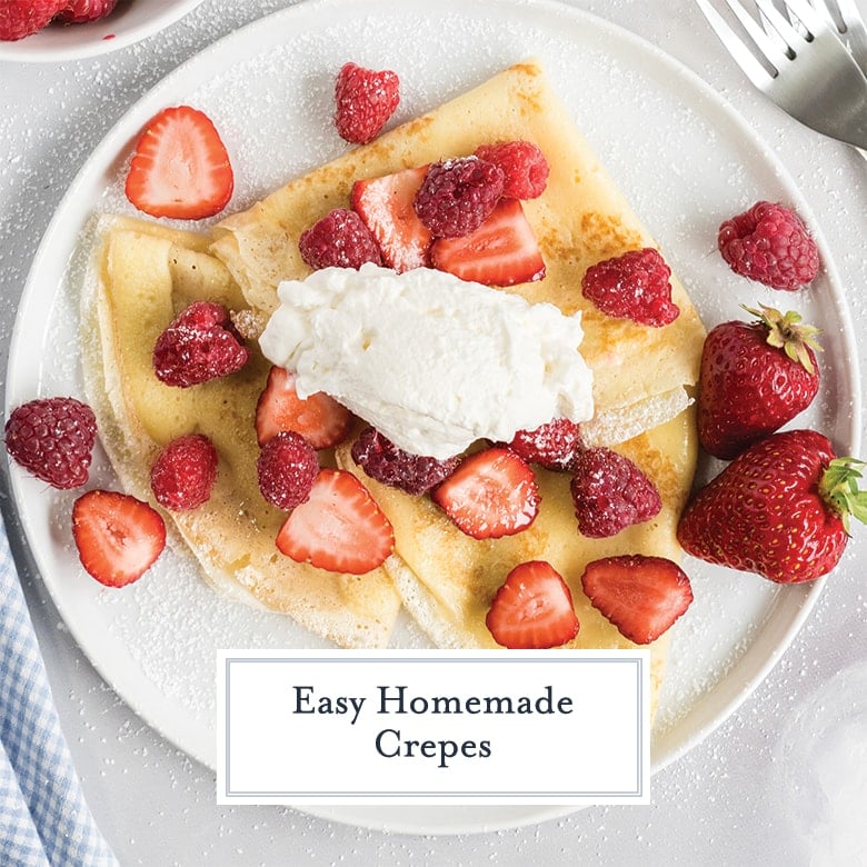 overhead of crepes with fresh berries, whipped cream and powdered sugar 