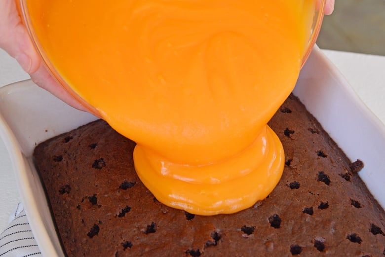 pouring pudding over poked cake 