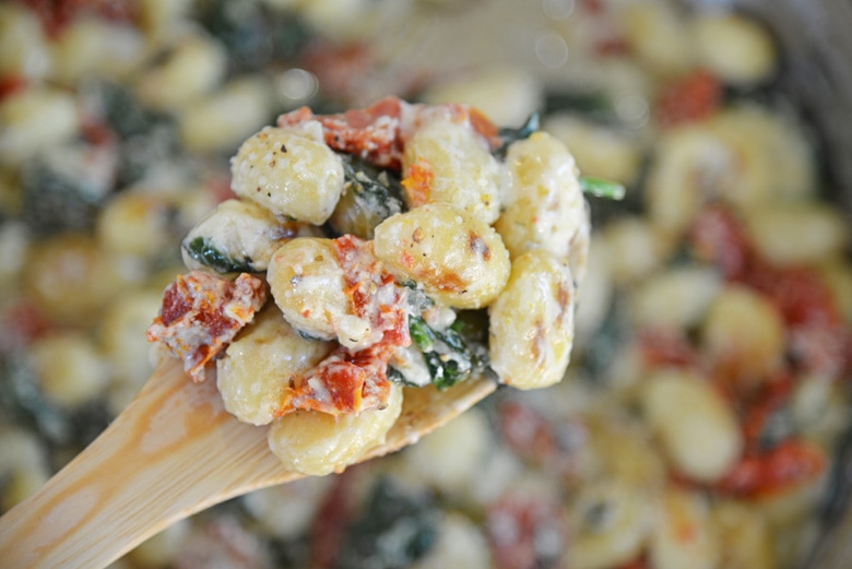 wooden spoon with creamy gnocchi 