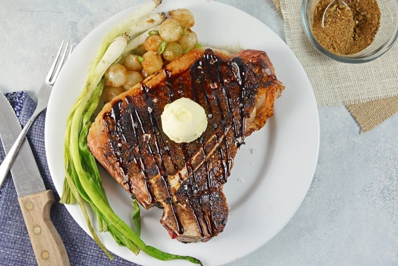 overhead of porcini rubbed steak on a white plate 