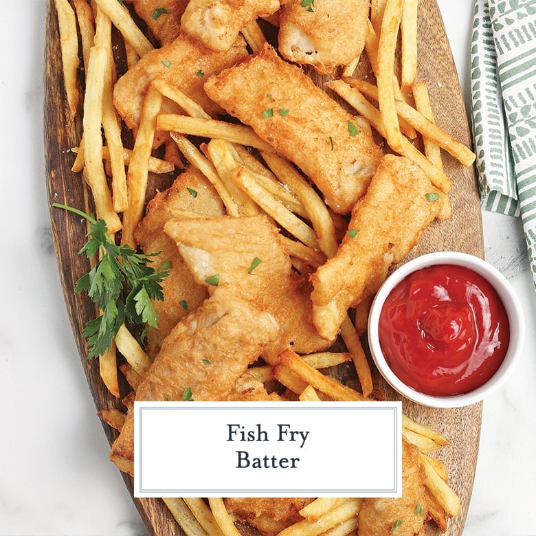 fish and chips on a wood serving board with dipping sauces 