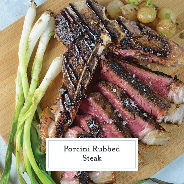 carved t bone steak on a cutting board with onions 