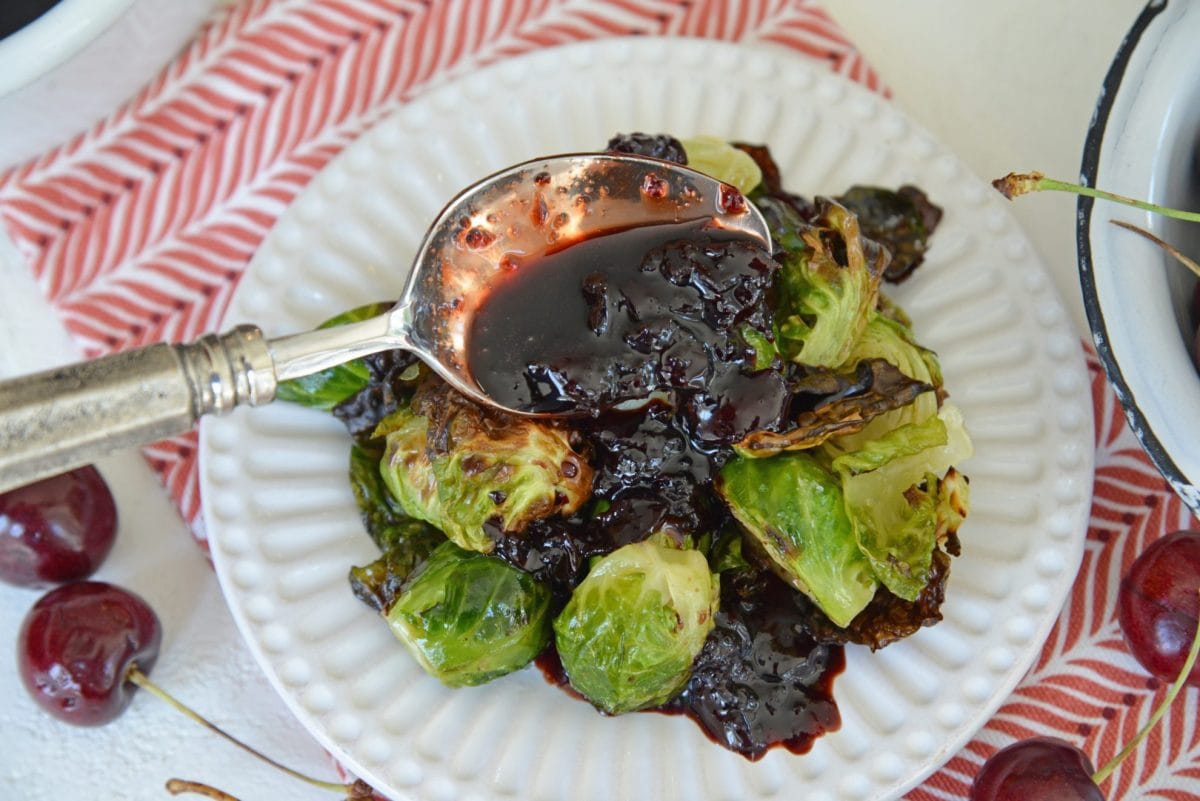 spooning balsamic sauce onto brussels sprouts 
