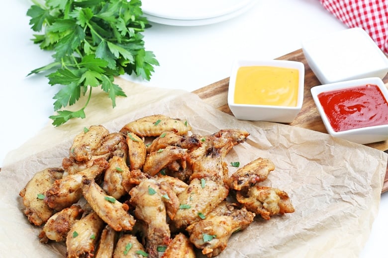 chicken wings on a serving platter with dipping sauce 