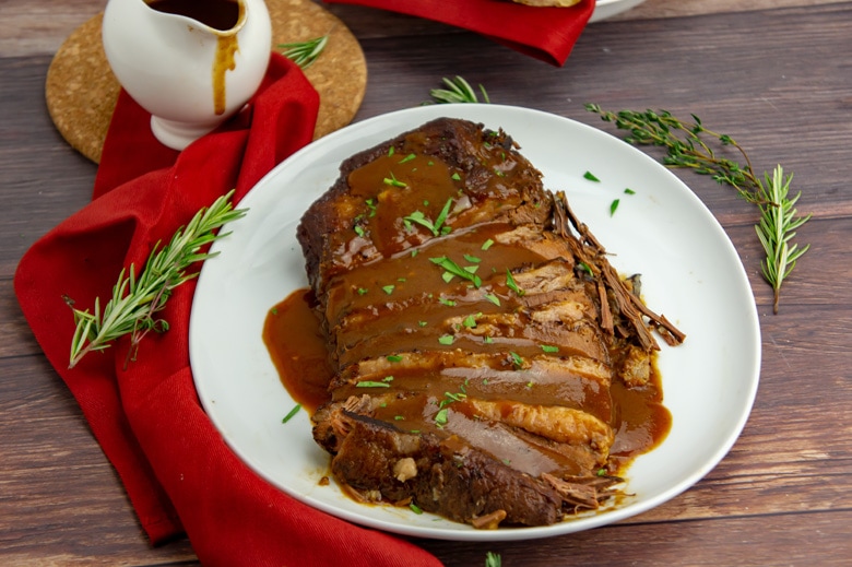 brisket with gravy on a white serving platters 