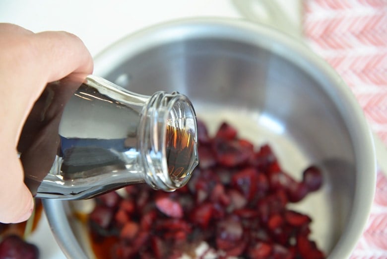 pouring balsamic vinegar into a saucepan 