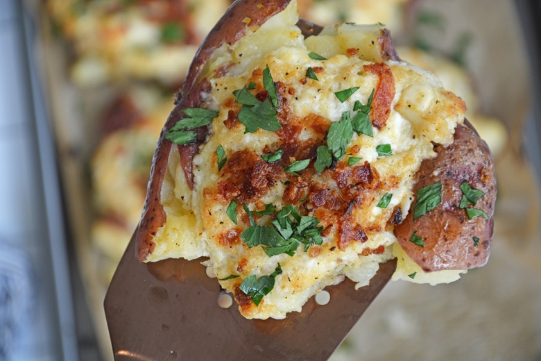 spatula holding a crab stuffed potato 