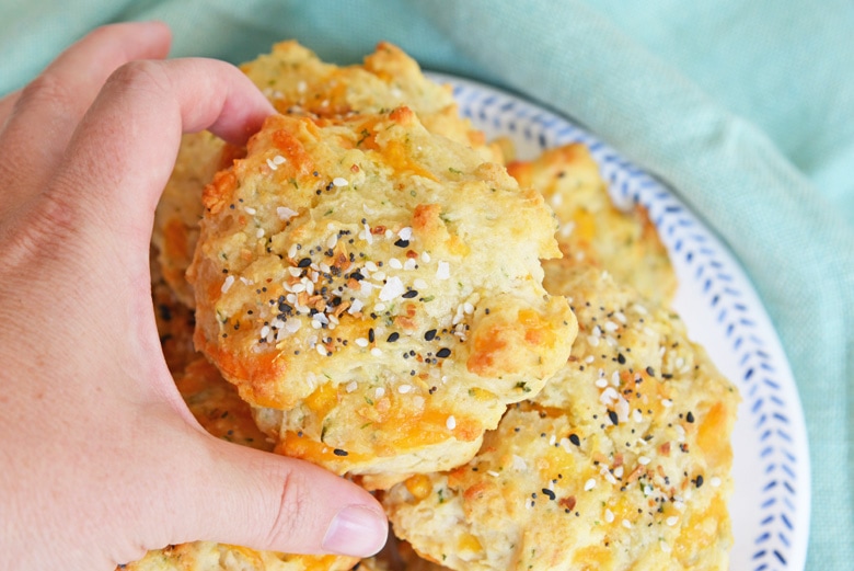 hand reaching for everything cheesy biscuit