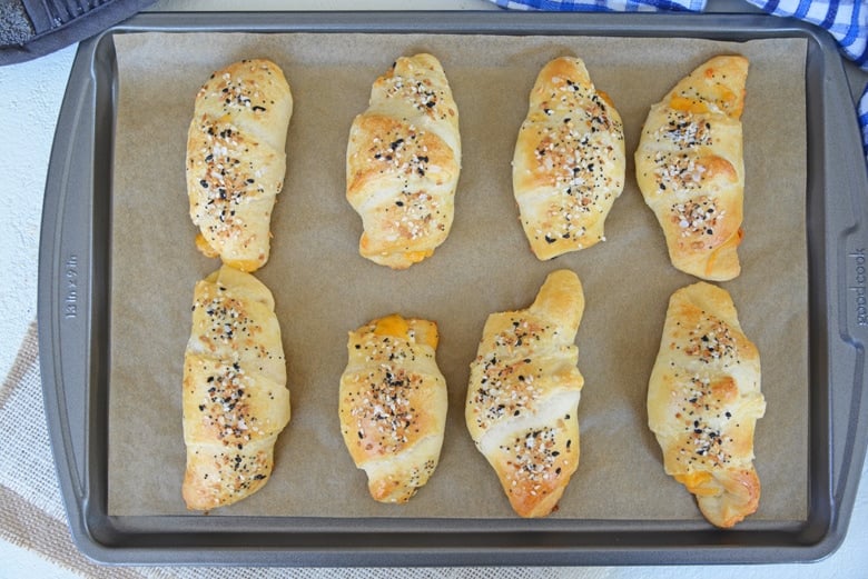 cheesy everything crescent rolls on a baking sheet  