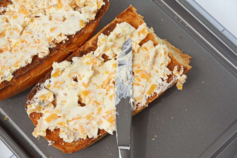 spreading cheese and butter into Italian bread 