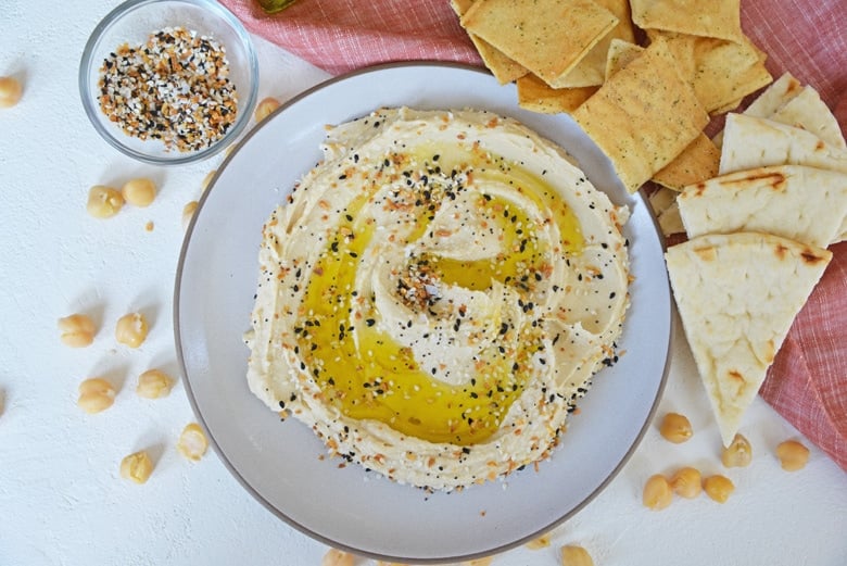 everything bagel seasoning on hummus with pita chips and pita bread 