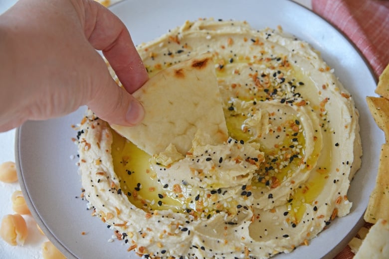 pita bread dipping into hummus 