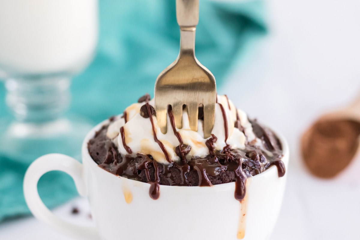 straight on shot of fork digging into mug brownie