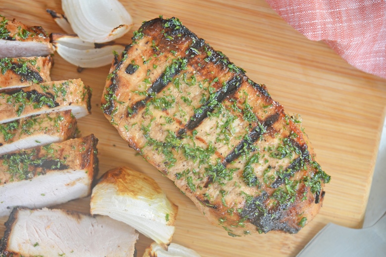 overhead of grilled pork chop on a cutting board