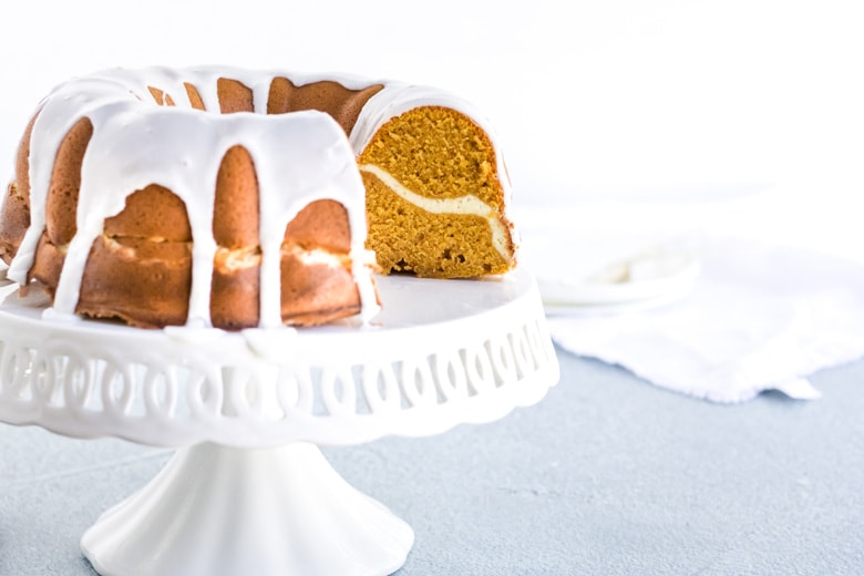 pumpkin cream cheese pound cake with icing on a cake plate