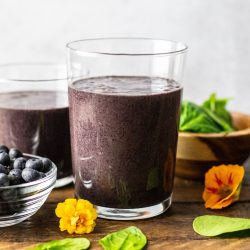 straight on shot of spinach blueberry smoothie in glass