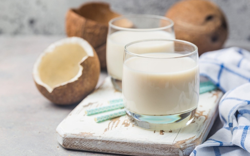 glass of coconut milk with blue straws