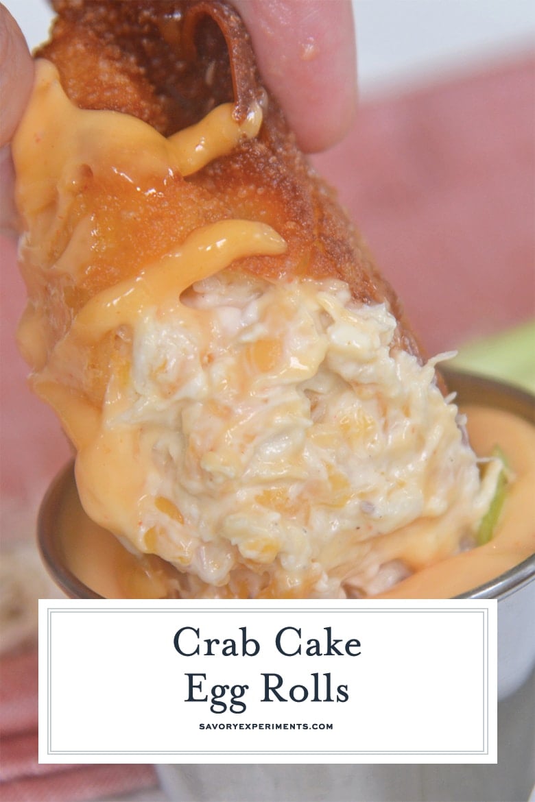 close up of crab cake egg roll dipping into sauce with text overlay for pinterest