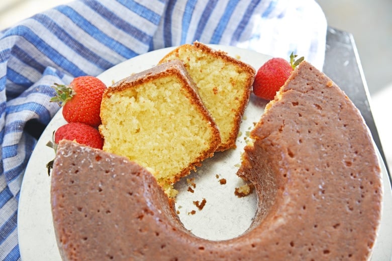 sliced butter cake on a platter with blue linens