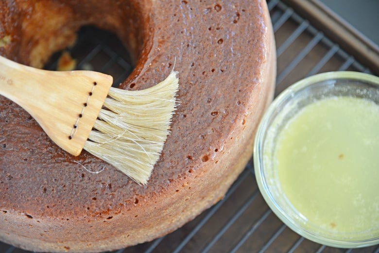 brush adding melted butter to cake