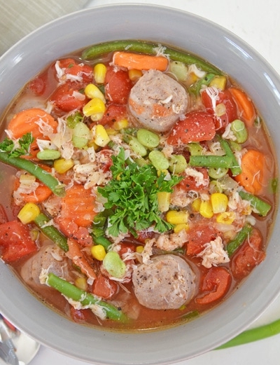 overhead of vegetable, crab and sausage soup