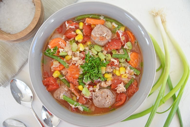 overhead of vegetable, crab and sausage soup