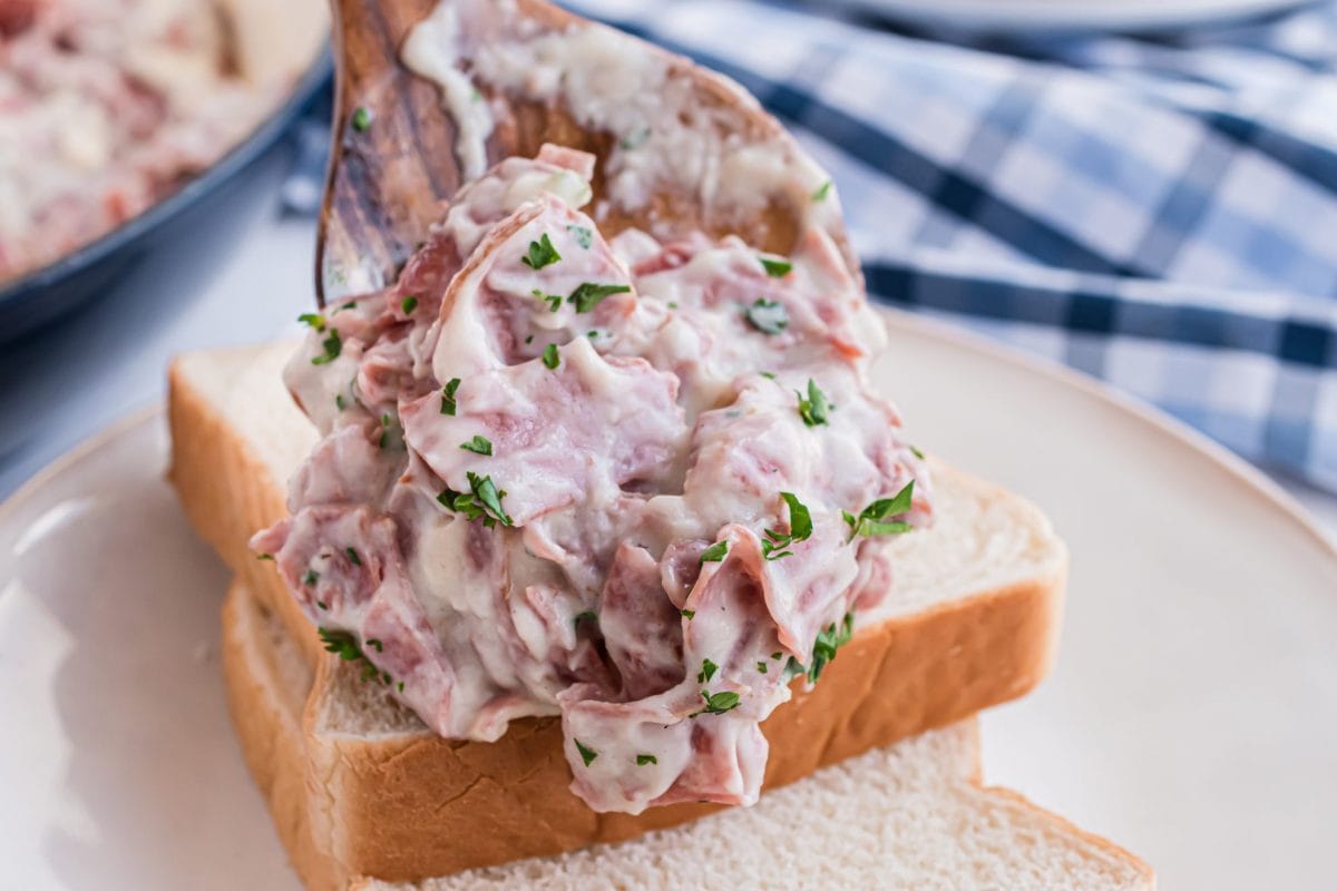 scooping chipped beef onto white bread 