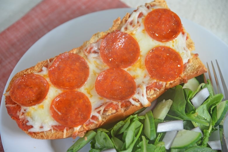 pepperoni pizza on a plate with salad 