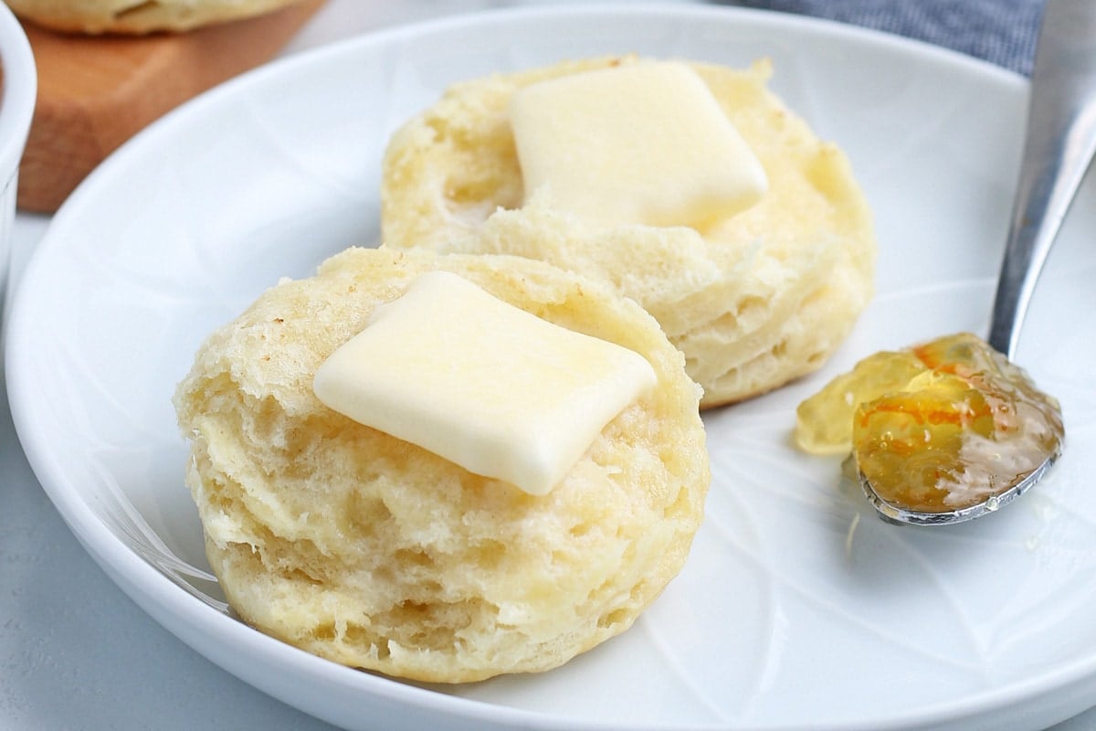 close up of buttered biscuit with jam 