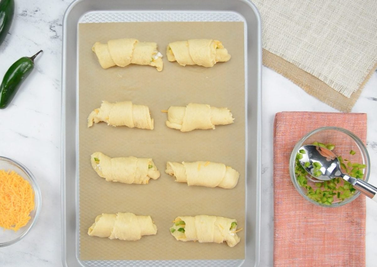 raw jalepno popper crescent rolls on baking sheet