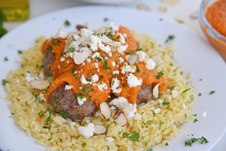 Lamb meatballs with romesco sauce pairs tender and flavorful mini meatballs with smoky homemade romesco sauce, feta cheese and crunchy almonds. #lambmeatballs www.savoryexperiments.com 