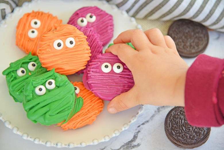 child's hand reaching for a mummy cookie 