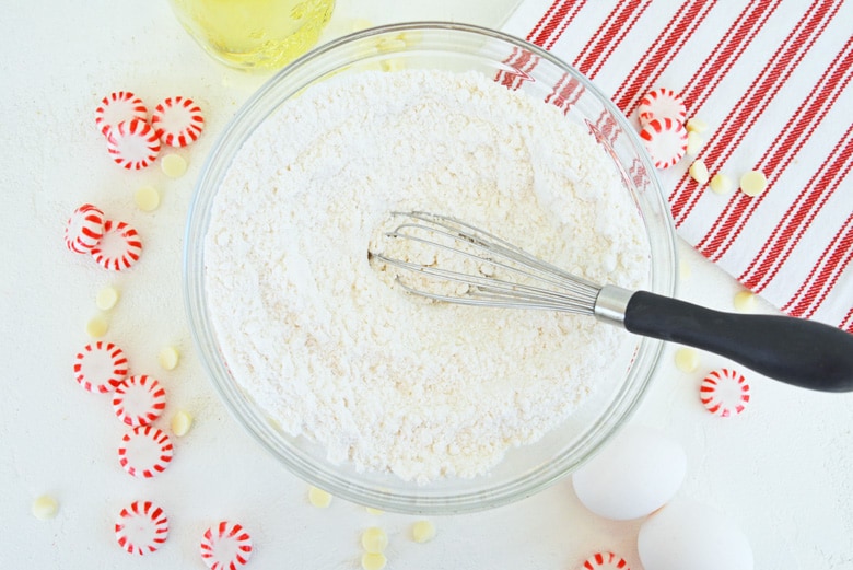 overhead shot of whisk in bowl of cake mix