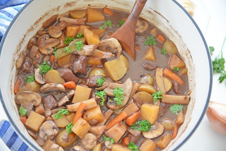 wooden spoon in a pot of red wine beef stew