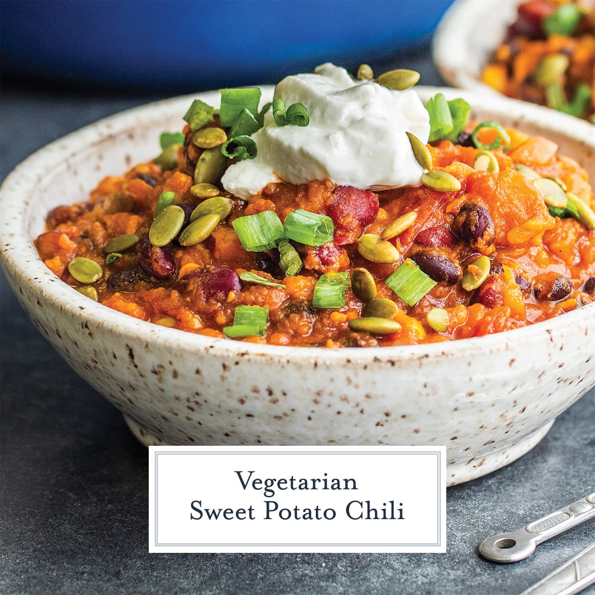 angle close up of vegetarian chili with sour cream and pepitas