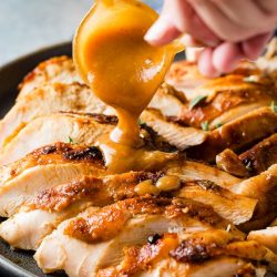 gravy pouring over sliced turkey breast