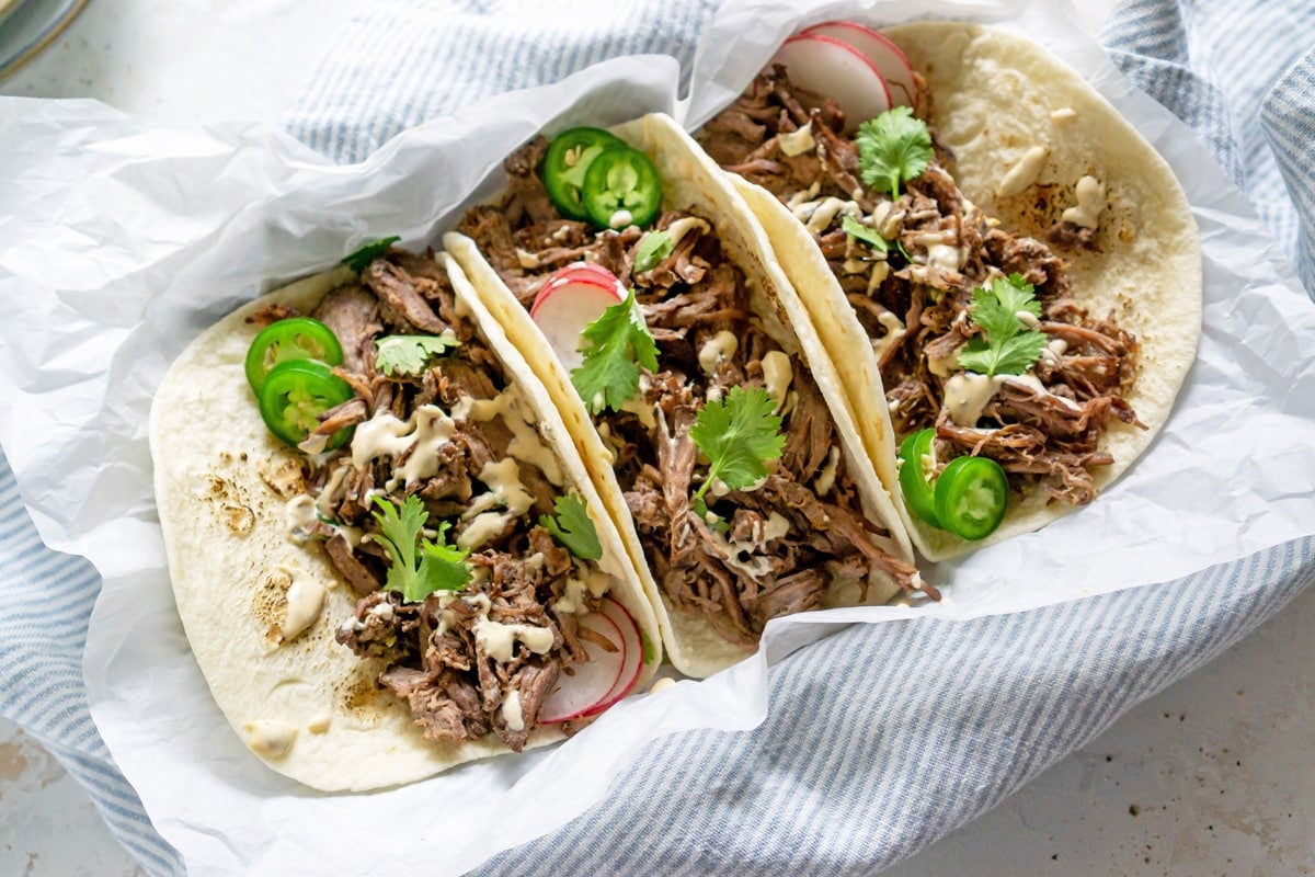 three tacos with jalapenos and cilantro 